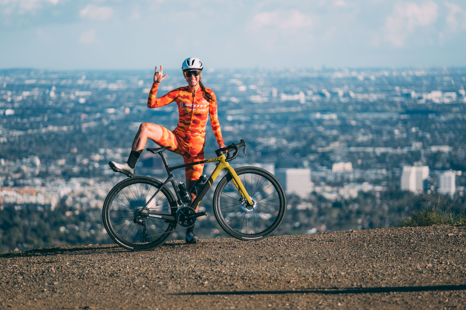Shimano gravel athlete Izy King standing with her Scott gravel bike in the hills above LA