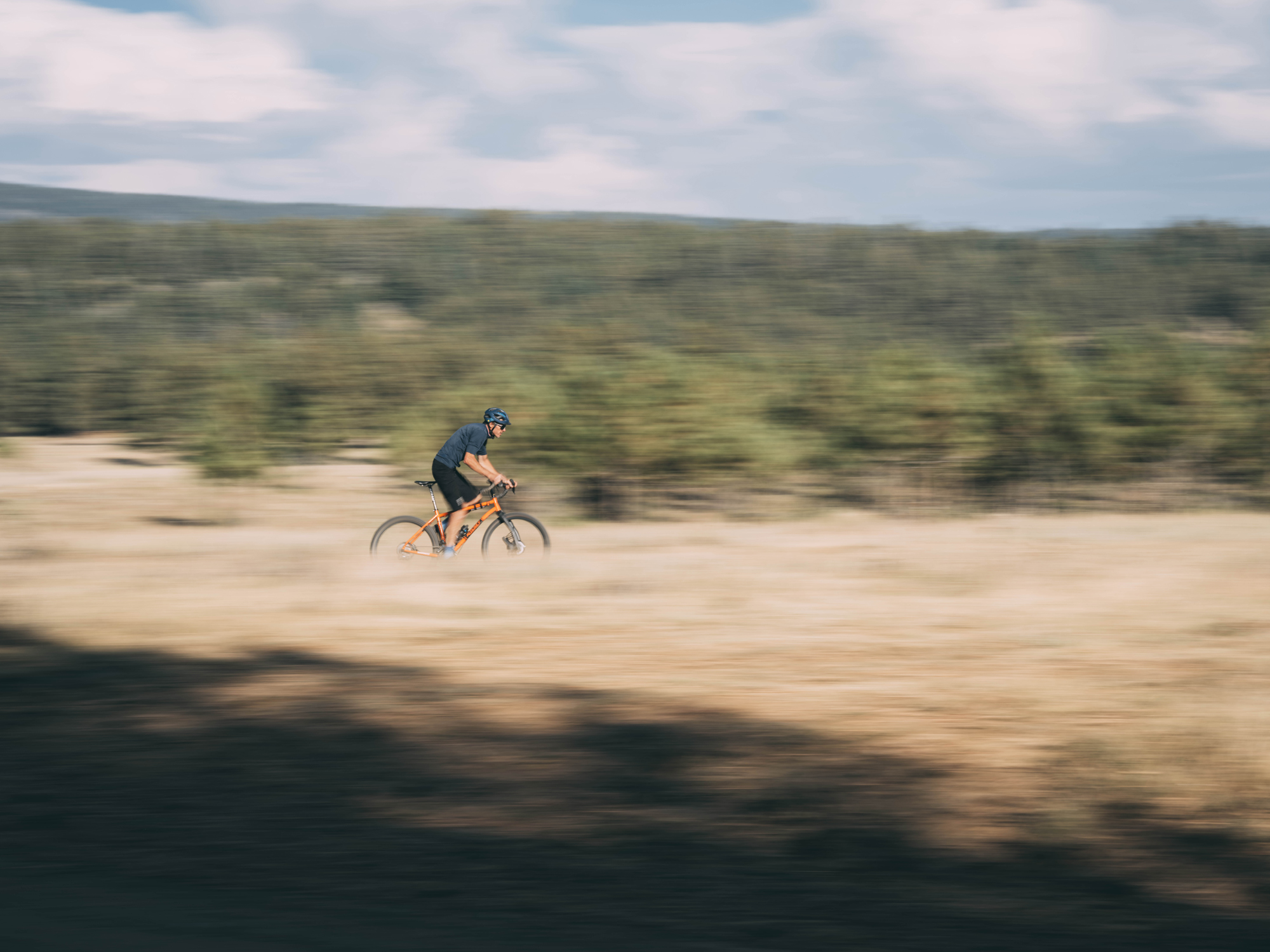 Alex Morgan som sykler på grussykkelen sin over New Mexicos sletter 