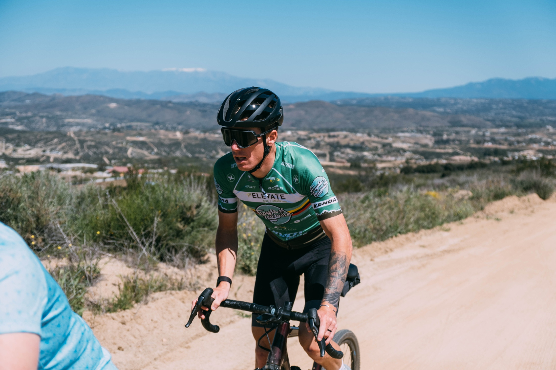 Taylor lidded climbing up a hill on his gravel bike